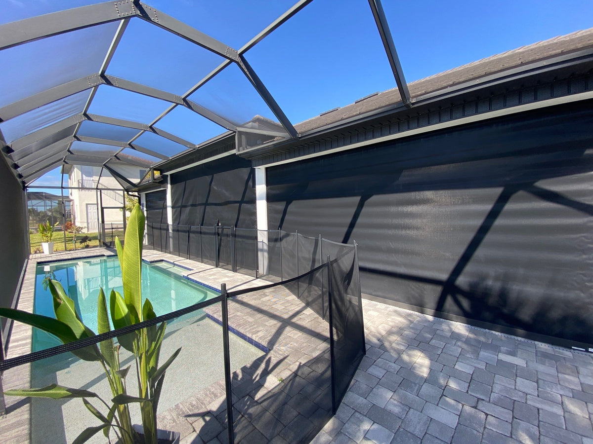 Dark hurricane screens closed across poolside lanai openings, with a separate pool enclosure in front.